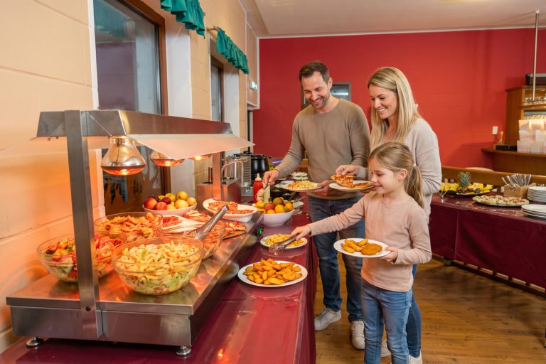 Familie bedient sich am All-you-can-eat-Buffet im Restaurant des Freizeitparks Landsberg: Salate, Pizza und warme Speisen unter der Wärmelampe
