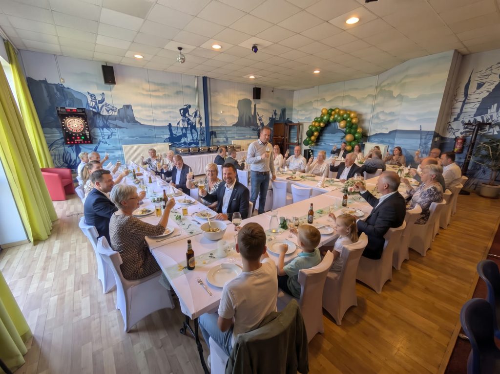 Geburtstagsfeier im Freizeitpark Landsberg: Gäste stoßen an einer voll besetzten Festtafel an