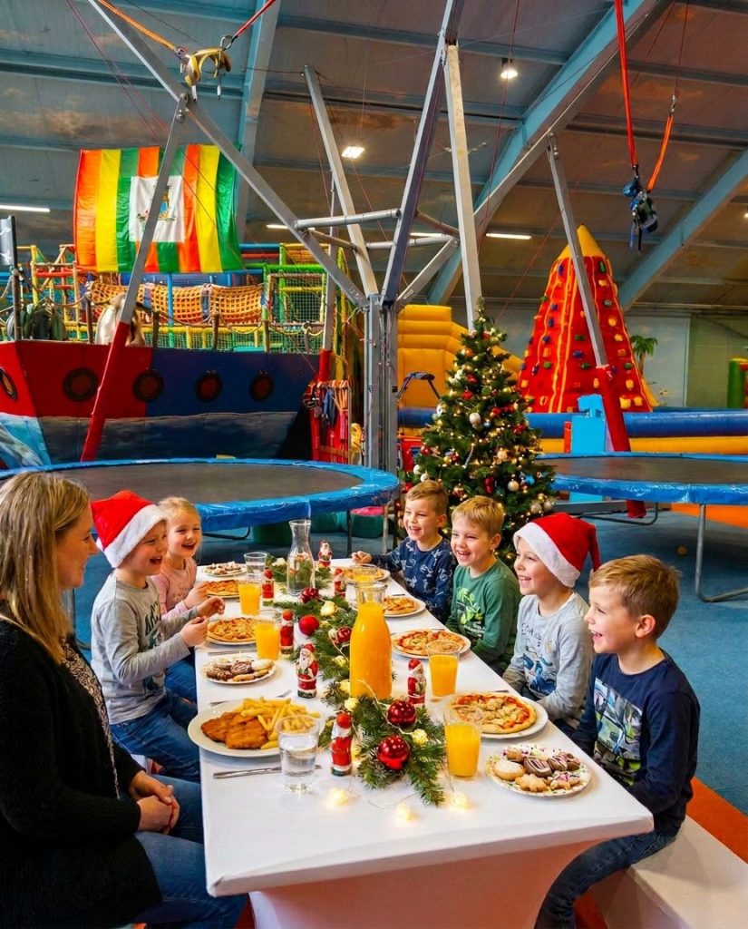 Kinder-Weihnachtsfeier mit Pizza am festlich gedeckten Tisch im Kinderparadies